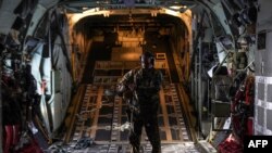 FILE— A member of the US Air Force 26th Expeditionary Rescue Squadron aboard an HC-130J aircraft prepares to airdrop humanitarian aid supplied by Jordan over the Gaza Strip, on March 14, 2024.