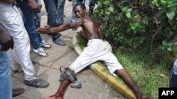 Injured man lies on ground after clash with police at market in Abobo neighborhood in Abidjan, Oct. 15, 2012.