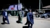 Kenyan police carrying batons and teargas patrol looking for people out after curfew in the Kibera slum in Nairobi, Kenya, March 29, 2020. 