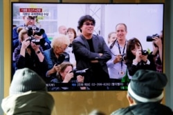 FILE -People watch a TV broadcasting a news report on&nbsp;South Korean director&nbsp;Bong&nbsp;Joon-ho who&nbsp;won&nbsp;four&nbsp;Oscars&nbsp;with his film "Parasite", in Seoul, South Korea, Feb. 10, 2020.