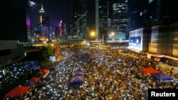 Para demonstran pro-demokrasi di Hongkong bernyanyi sambil melambaikan telepon genggam mereka dalam sebuah aksi protes di luar gedung pemerintah di Hong Kong (10/10).