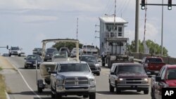 Numerosos automovilistas cruzan un puente levadizo en Wrightsville Beach, Carolina del Norte, mientras evacuan la zona ante la llegada del huracán Florence, el martes 11 de septiembre de 2018. (AP Foto/Chuck Burton) 