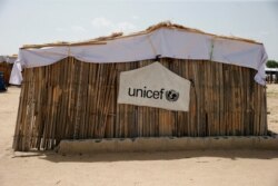 FILE PHOTO: A banner with the UNICEF logo is seen hanging on a makeshift school at an internally displaced persons camp on the outskirts of Maiduguri, northeast Nigeria, June 6, 2017.
