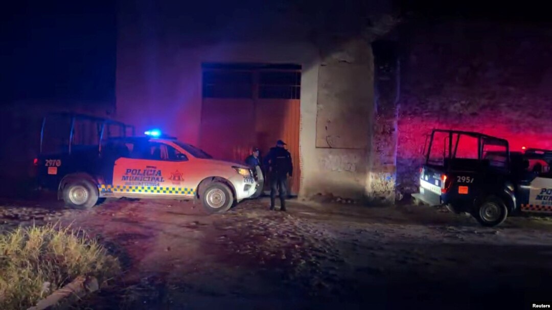 Vehículos y agentes policiales fuera del lugar donde un grupo armado abrió fuego a participantes de una fiesta en Salvatierra, Guanajuato.