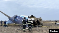 Petugas tanggap darurat memeriksa bagian pesawat Azerbaijan Airlines yang mengalami kecelakaan di dekat Kota Aktau, Kazakhstan, pada 25 Desember 2024. (Foto: Kazakhstan Emergencies Ministry/Handout via Reuters)