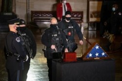 U.S. Capitol Police officers pay their respects to U.S. Capitol Police officer Brian Sicknick as an urn with his cremated remains lies in honor on a black-draped table at the center of the Capitol Rotunda, Wednesday, Feb. 3, 2021, in Washington. …