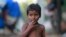 FILE - A child eats a pomegranate collected from waste at a slum area on the outskirts of Jammu, India, Oct. 12, 2018. 