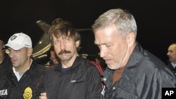 This image provided by the Drug Enforcement Administration shows Russian arms trafficking suspect Viktor Bout, center, in U.S. custody after being flown from Bangkok to New York, 16 Nov 2010