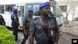 Des agents de sécurité montent la garde devant un bus transportant tous les gouverneurs de l'opposition du Congrès après leur visite aux victimes dede l'explosion de lundi à Abuja, au Nigeria , le 16 avril 2014.