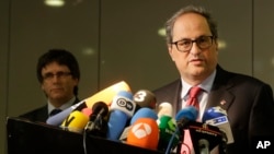 Former Catalan leader Carles Puigdemont, left, and Catalan president Quim Torra, right, attend a news conference in Berlin, Germany, May 15, 2018.