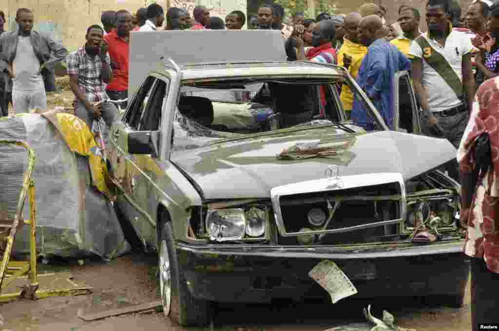 People gather at the site of an explosion at Sabon gari in Kano, Nigeria. Tuesday, July. 30, 2013. 