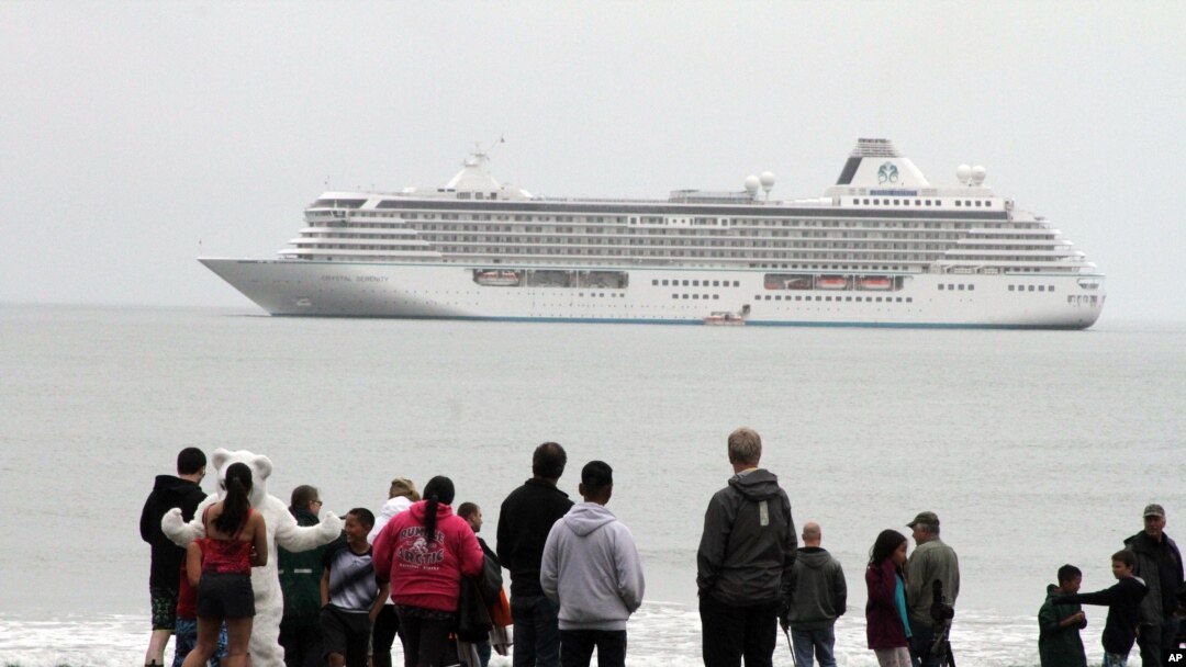 FILE - People prepare to take a polar plunge in the Bering Sea in front of the luxury cruise ship Crystal Serenity, which anchored just outside Nome, Alaska, Aug. 21, 2016. The ship made a port call as it became the largest cruise ship to ever go through the Northwest Passage, en route to New York City.