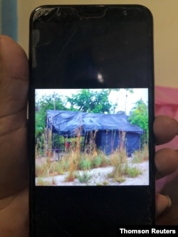 FILE - A resident displays a photo on her phone of the tents where she said the guerrillas sleep, near the Colombian border, outside Puerto Ayacucho, Amazonas, Venezuela Dec. 2, 2020.