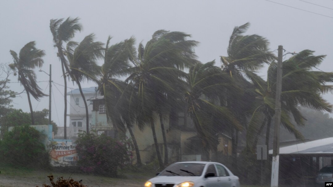 Sebuah mobil melaju di jalan saat Badai Tropis Laura menghantam Guayama, Puerto Rico pada 22 Agustus 2020. (Foto: AFP/Ricardo Arduengo)