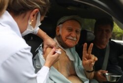 An elderly resident receives Sinovac's coronavirus disease (COVID-19) vaccine at a drive-thru center for seniors citizens in Rio de Janeiro, Brazil, Feb. 5, 2021.