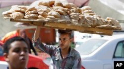 An Egyptian vendor carries bread downtown Cairo, Egypt, Aug. 5, 2013.