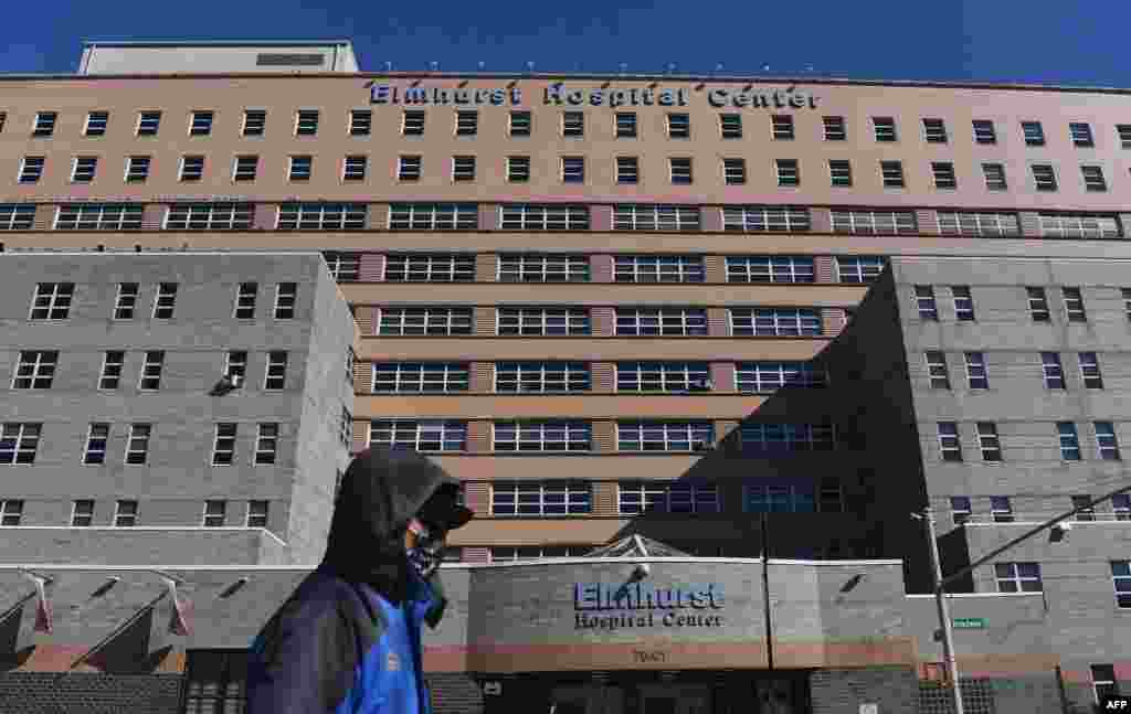 지난해 3월 신종 코로나바이러스 감염이 대량 발생했던 뉴욕주 퀸즈의 엘므허스트 병원 앞을 마스크를 쓴 시민이 지나가고 있다. 
