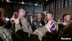 Soldiers take photos as U.S. President Barack Obama, center, shakes hands with troops after delivering remarks at Bagram air base in Kabul, Afghanistan, May 25, 2014. 