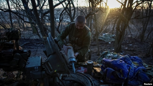 A Ukrainian serviceman prepares tank munitions for upload, amid Russia's invasion of Ukraine, in the country's eastern Luhansk region, Feb. 18, 2024.