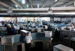 FILE - Journalists stand in the newsroom of Venezuela's El Nacional newspaper after it published its last print edition, after struggling for years under government pressure and a collapsing economy, in Caracas, Venezuela, Dec. 14, 2018.