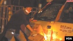 杨家伦旺角骚乱时将烧着的纸箱放在的士旁（苹果日报视频截图）