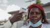 FILE - A health worker gets her temperature checked during the launch of the mpox vaccination campaign at the General Hospital of Goma, Oct. 5, 2024. 