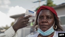 FILE - A health worker gets her temperature checked during the launch of the mpox vaccination campaign at the General Hospital of Goma, Oct. 5, 2024. 