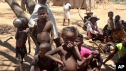 Des enfants se protègent du soleil à Ankilimarovahatsy, à Madagascar, un village de l'extrême sud de l'île où la plupart des enfants souffrent de malnutrition aiguë, le 9 novembre 2020.