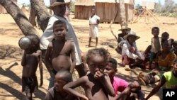 FILE - Children shelter from the sun in Ankilimarovahatsy, Madagascar, a village in the far south of the island where most children are acutely malnourished, Nov. 9, 2020.