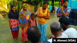 Osman Goni, with his wife and two children, showing some villagers the copies of some of the documents he had submitted to the authorities last year, seeking inclusion to the NRC of all members of his extended family, Aug. 2, 2018. When the NRC draft was 