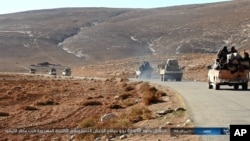 FILE - This image posted online on Saturday, Dec. 10, 2016, by supporters of the Islamic State militant group on an anonymous photo sharing website, purports to show a convoy of vehicles of IS driving in a desert area of east of Palmyra city, in Homs, Syr