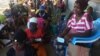 Deslocados, vítimas, da violência armada em Cabo Delgado aguardam na rua com as senhas para adquirir os seus produtos através da ajuda do PMA, em Pemba.