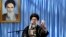 Iranian supreme leader's office, Supreme Leader Ayatollah Ali Khamenei delivers a speech in a ceremony marking the anniversary of the death of the late revolutionary founder Ayatollah Khomeini, shown in the picture at background, June 4, 2013.