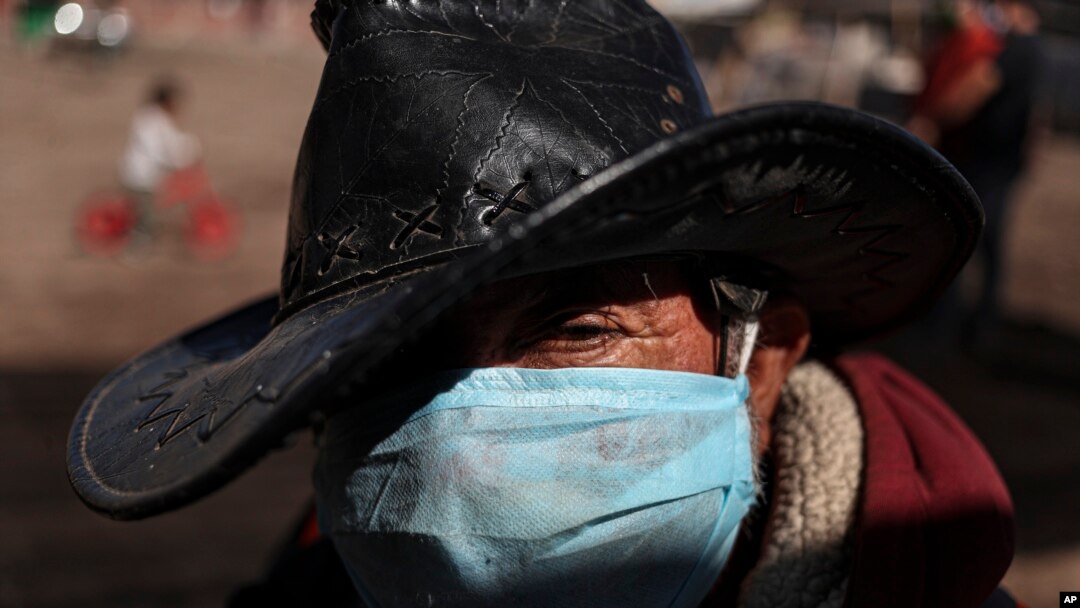 Hernaldo Gutierrez, wearing a protective face mask, waits in line to receive free fruits and vegetables in Quillicura, on the outskirts of Santiago, Chile, April 29, 2020.