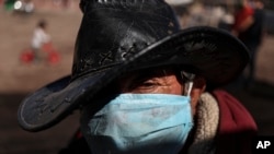 Hernaldo Gutierrez, wearing a protective face mask, waits in line to receive free fruits and vegetables in Quillicura, on the outskirts of Santiago, Chile, April 29, 2020.