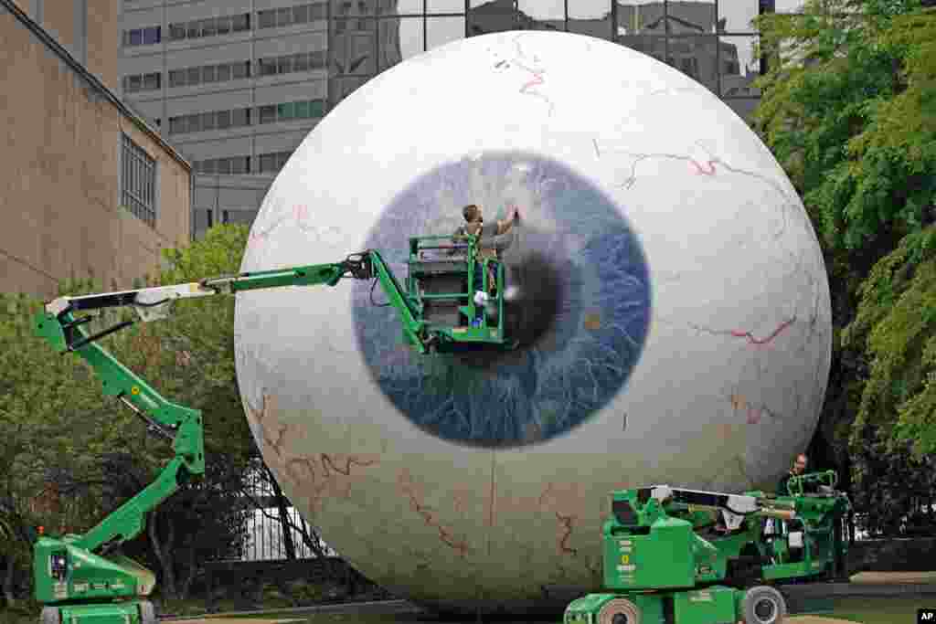 Workers restore the fiberglass sculpture called &quot;The Eye&quot; created by artist Tony Tasset in downtown Dallas, Texas. The he 30-foot giant eye was vandalized.