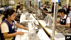 ကမ္ဘောဒီးယားနိုင်ငံ၊ ဖနွမ်းပင်မြို့တော်ရှိ အထည်ချုပ်စက်ရုံ တစ်ခု စက်ချုပ်နေကြသည့် အလုပ်သမားများ။ သြဂုတ် ၄၊ ၂၀၀၇။
