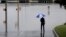 A man surveys floodwaters caused by heavy rains, May 25, 2013, in San Antonio.