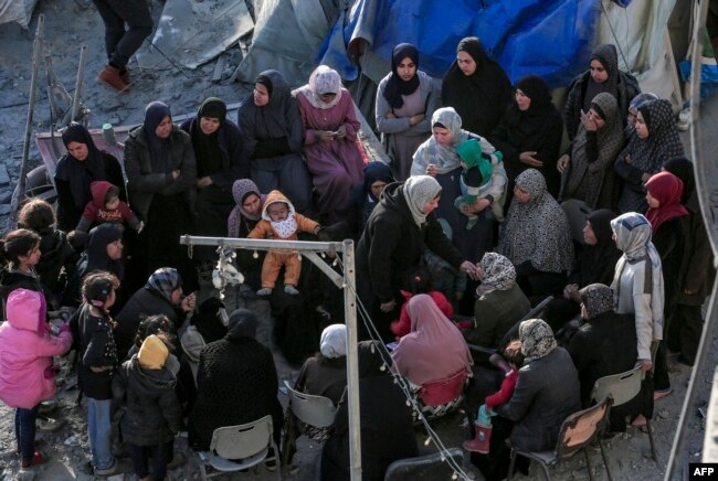 Warga Palestina duduk di tengah tenda dan tempat penampungan sementara yang hancur akibat serangan Israel di Deir el-Balah di Gaza tengah pada 2 Maret 2024. (Foto: AFP)