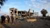 Orang-orang melihat sisa-sisa bangunan yang dihancurkan oleh serangan udara Israel di Kota Gaza, Senin, 13 Februari 2023. (AP Photo/Adel Hana)