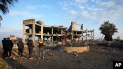 Orang-orang melihat sisa-sisa bangunan yang dihancurkan oleh serangan udara Israel di Kota Gaza, Senin, 13 Februari 2023. (AP Photo/Adel Hana)