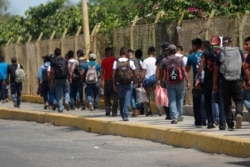 FILE - Central American migrants cross into Mexico from Guatemala, near Ciudad Hidalgo, Mexico, June 4, 2019.