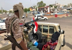 A fighter mans the turret of a pickup truck mounted with an anti-aircraft gun displaying the southern Yemeni separatist flag in Khor Maksar in the center of Aden, Yemen, Aug. 12, 2019.