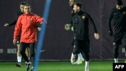 L'entraîneur de Barcelone Ernesto Valverde, à gauche, s'entretient avec l'attaquant argentin Lionel Messi lors d'une séance d'entraînement au centre sportif Joan Gamper du FC Barcelona à Sant Joan Despi, près de Barcelone, 25 novembre 2017.