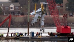 Rescue and salvage crews with cranes pull up the wreckage of an American Airlines jet in the Potomac River from Ronald Reagan Washington National Airport, Feb. 3, 2025, in Arlington, Va.