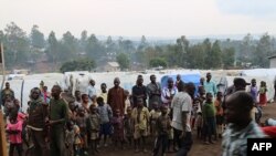 Des réfugiés se tiennent dans un camp de déplacés à l'extérieur de la ville de Bunia, dans la province d'Ituri, le 21 juin 2019.