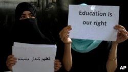 FILE - Afghan girls hold an illegal protest to demand the right to education in a private home in Kabul, Afghanistan, Aug. 2, 2022.