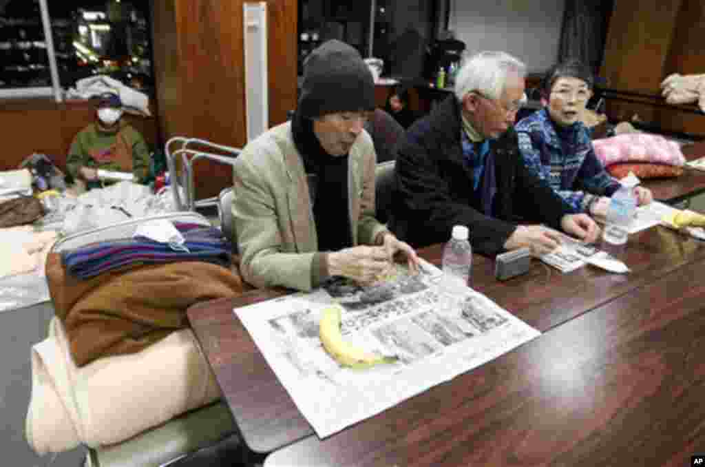 Survivors of the earthquake-triggered tsunami eat food at a shelter in Sendai, Miyagi Prefecture. (AP Image)