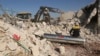 Syrian rescuers search for victim between rubble of a destroyed house after deadly airstrikes at the northern town of Sarmin, in Idlib province, Syria, Sunday, Feb. 2, 2020. (AP Photo/Ghaith Alsayed)