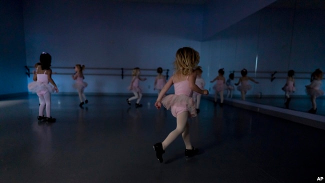 Alyssa Carpenter, 3, runs around in tap shoes during "Dance Party" at Tiny Tot ballet and tap class. Alyssa has had COVID-19 twice and suffers long-term symptoms.